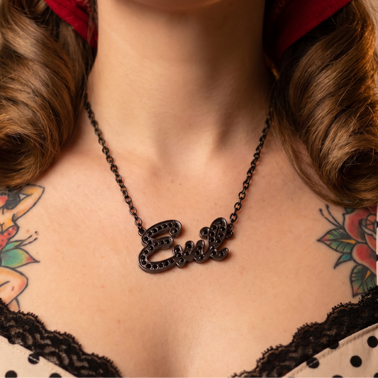 Person wearing a necklace with the name 'Evie' on a neutral background