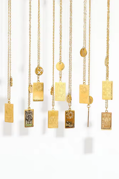 Gold necklaces with various pendants on a white background
