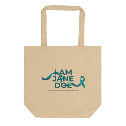 A beige canvas tote bag with two handles, featuring a teal graphic print that reads 'I AM JANE DOE' with a ribbon design and the words 'ADVOCACY | AWARENESS | EMPOWERMENT' underneath, shown on a plain white background.