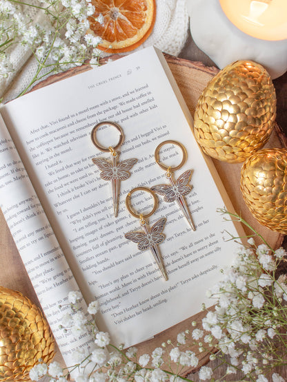 Faerie Dagger Enamel Keychain by Meaggie Moos, hard enamel dagger with gold accents on a book