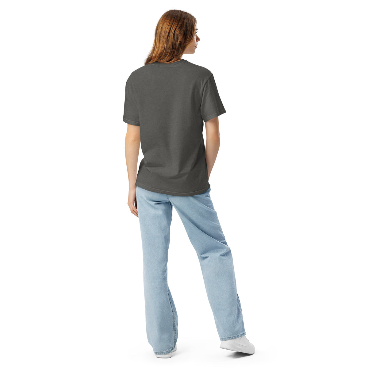 Person wearing a dark gray t-shirt and light blue jeans on a white background