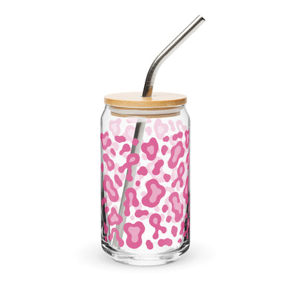 A clear glass can-shaped tumbler with a pink leopard print pattern, a light wood lid, and a curved stainless steel straw, shown on a white background.