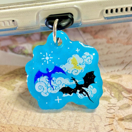 Blue dragon-themed kindle charm attached to a metallic object with a blurred background