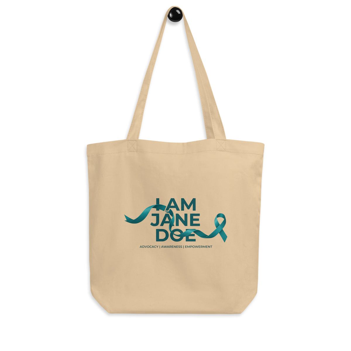 A beige canvas tote bag with two shoulder straps, featuring a teal graphic print on the front that reads 'I AM JANE DOE / ADVOCACY | ACCOUNTABILITY | EMPOWERMENT' with a teal ribbon shown against a plain white background.