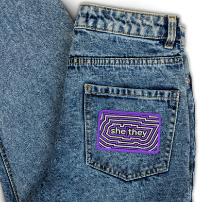 SheThey Pronoun Embroidered Patch Spinsterly Co LGBTQIA accessory on blue denim, geometric twill design
