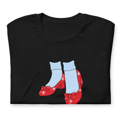 Folded black Friends of Dorothy tee showing the ruby-slipper and striped-sock print up close.
