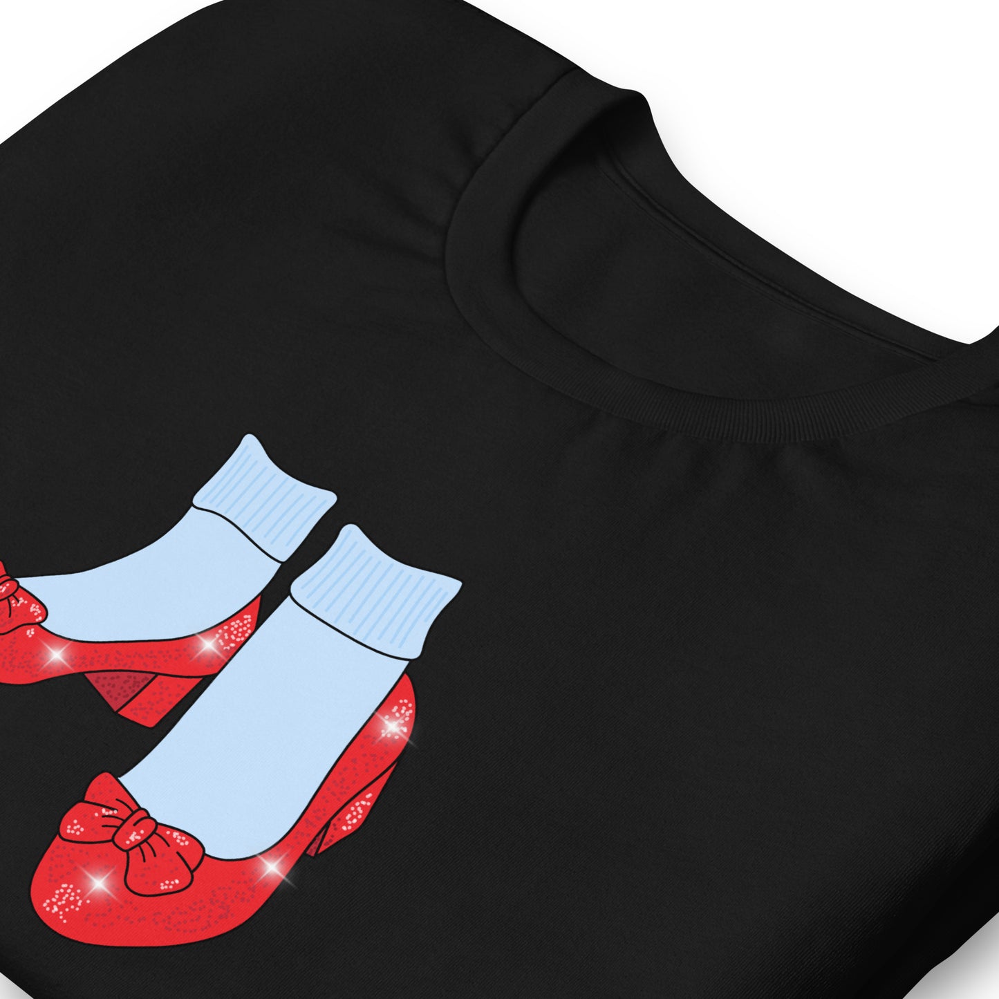 Folded black Friends of Dorothy tee showing the ruby-slipper and striped-sock print up close.