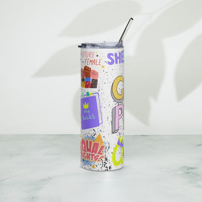 A white insulated tumbler with a clear lid and metal straw, decorated with colorful retro-style text and graphic stickers including 'SHERO' in purple, yellow, and pink. The tumbler is standing on a light marble surface against a white wall with soft leaf shadows.