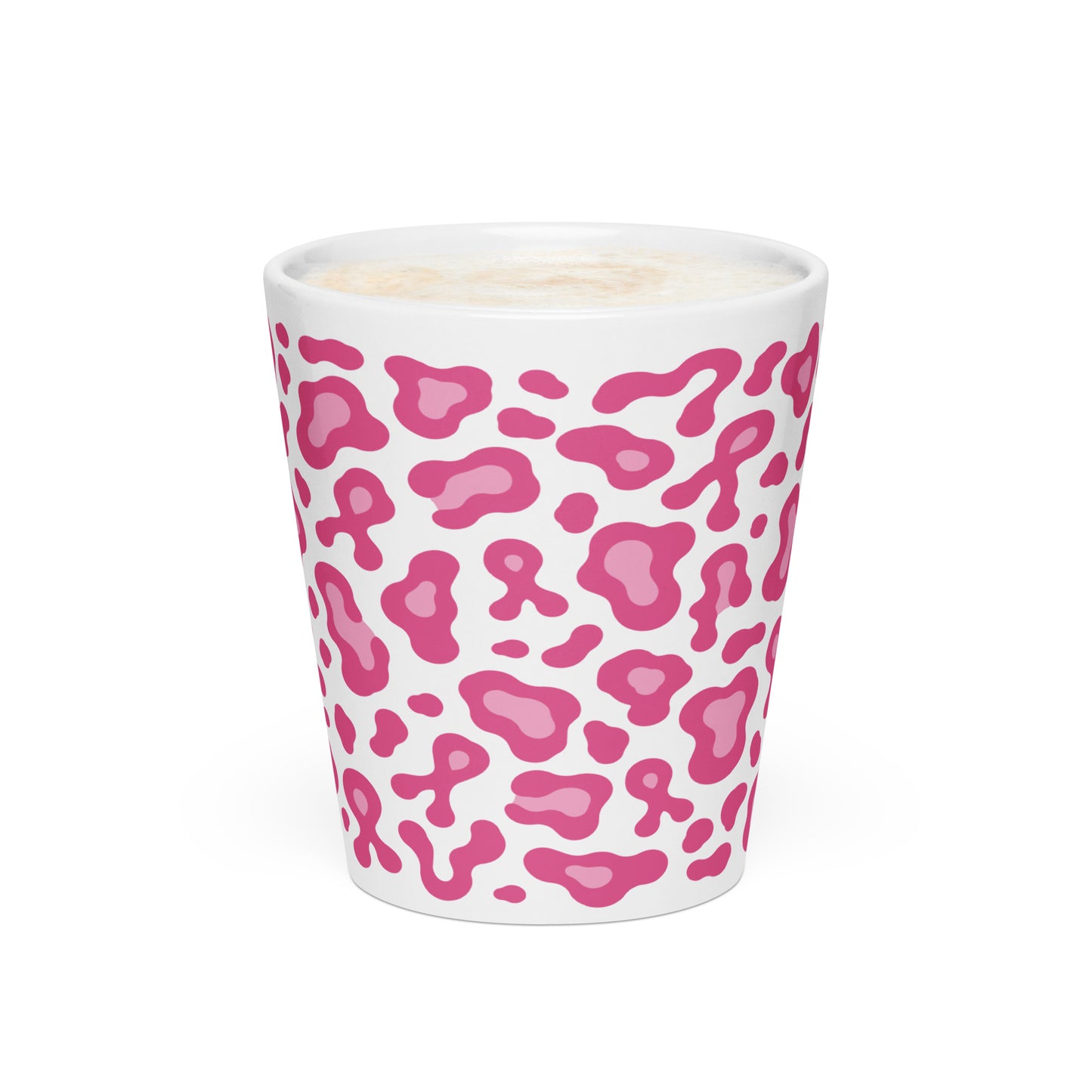 A white ceramic shot glass featuring a pink leopard print pattern, filled with a light-colored beverage and topped with foam, set against a plain white background.