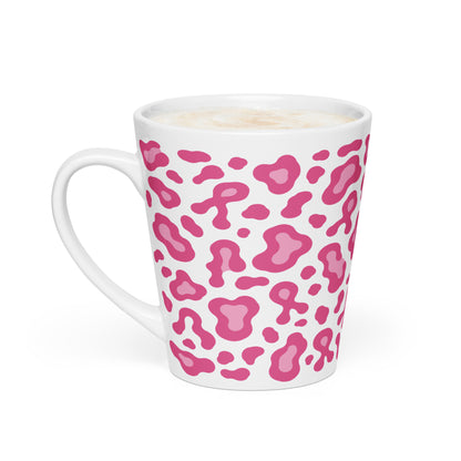 A white ceramic latte mug with a pink leopard print pattern, filled with a frothy coffee or latte, on a clean white background.