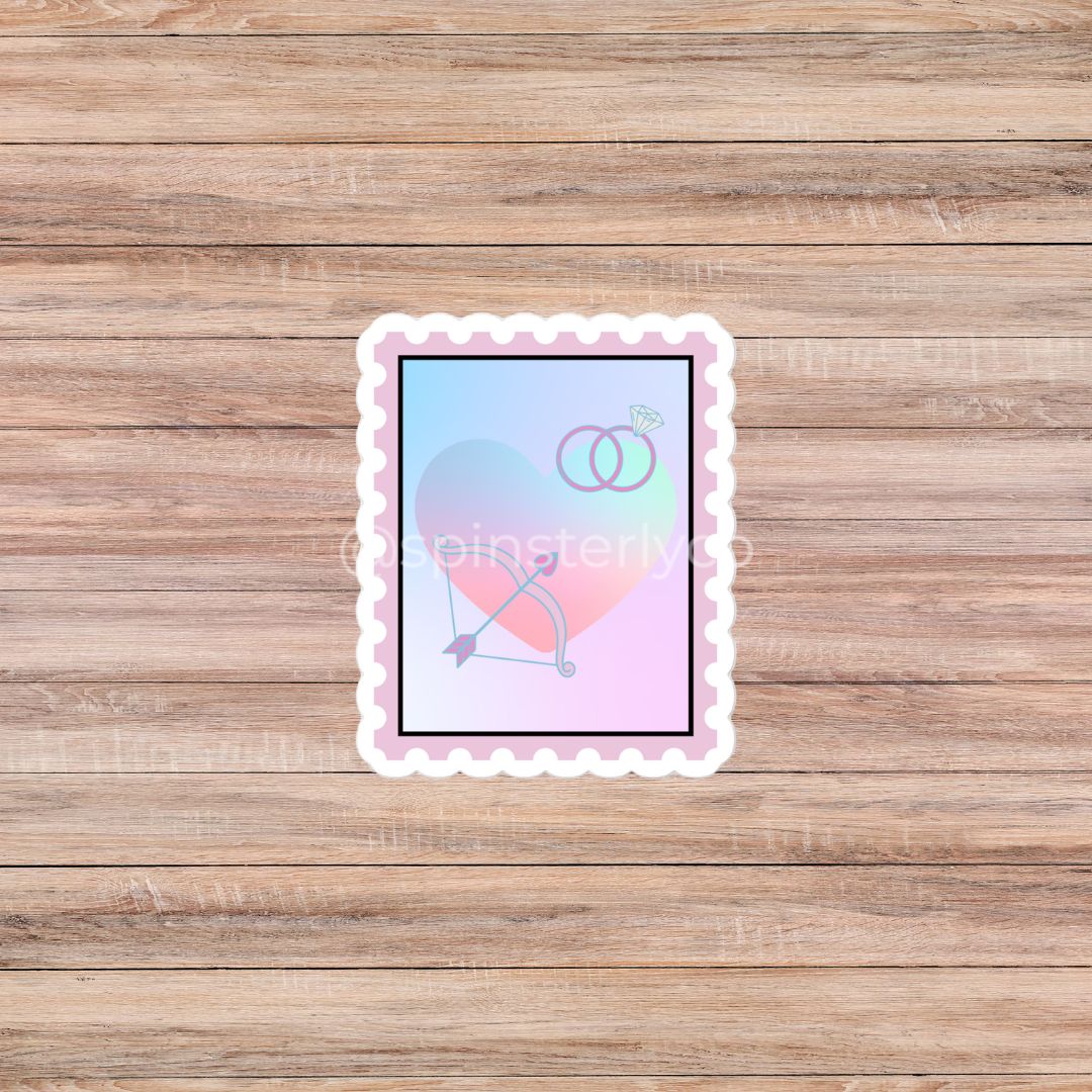 A rectangular scalloped sticker featuring a pastel gradient background with a bow and arrow and two interlocking rings, displayed on a light brown wood plank surface.