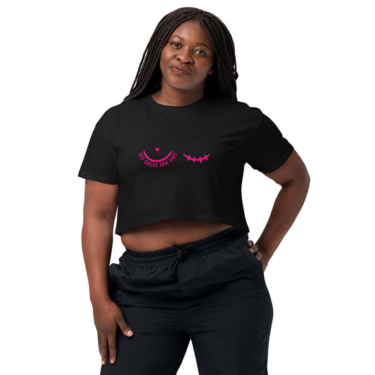 Woman wearing a black t-shirt pink breast cancer awareness graphic featuring a pair of half circles, one with a heart above it and text 'self-checks save lives' the other with mastectomy stiches on a white background