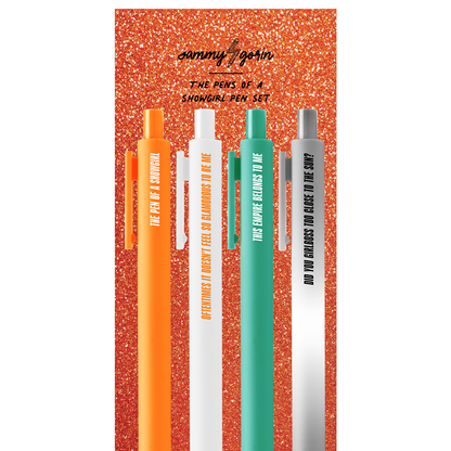 Set of four pens with orange, white, green, and gray colors on a glittery red background.