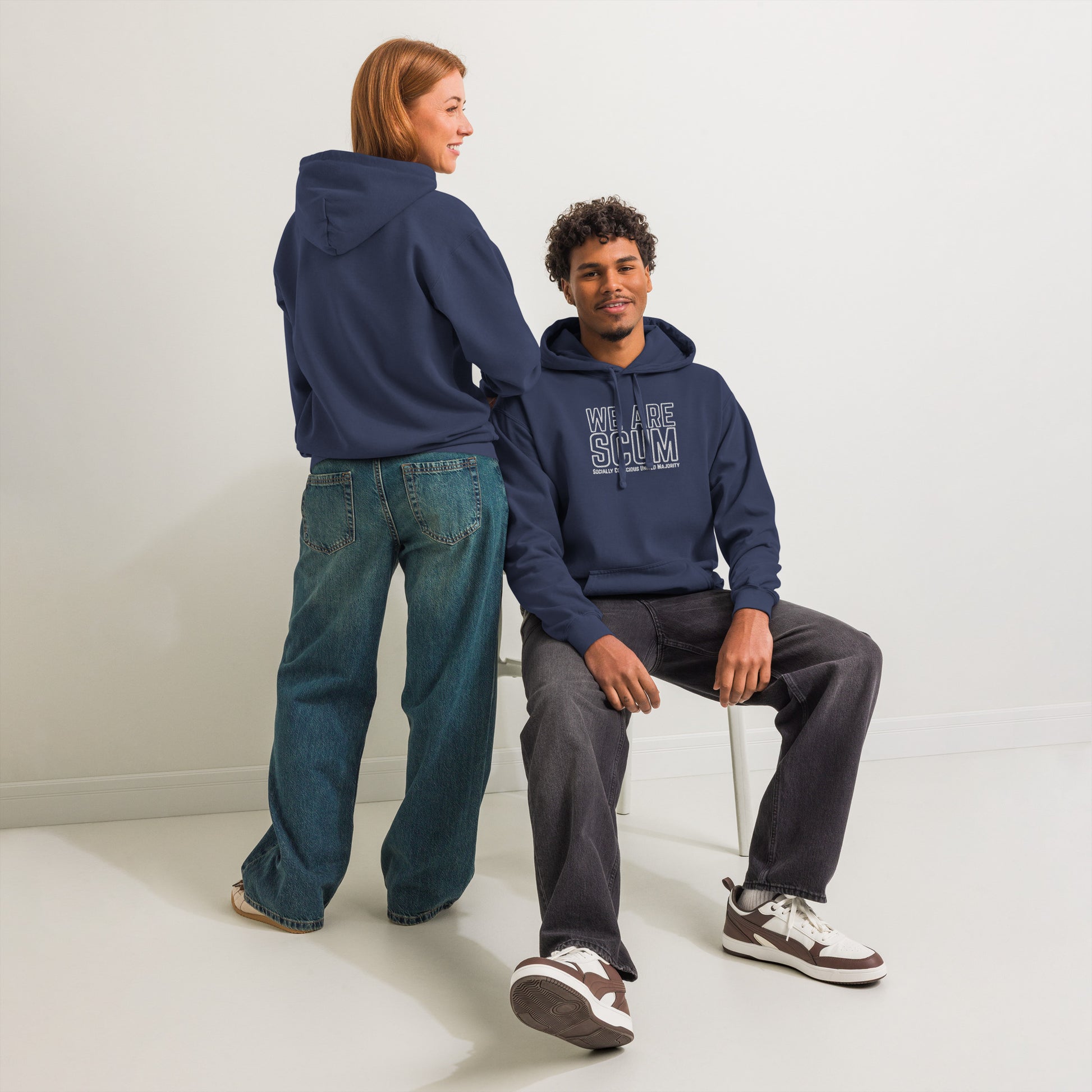 Two people wearing navy blue hoodies with brand logos on a white background
