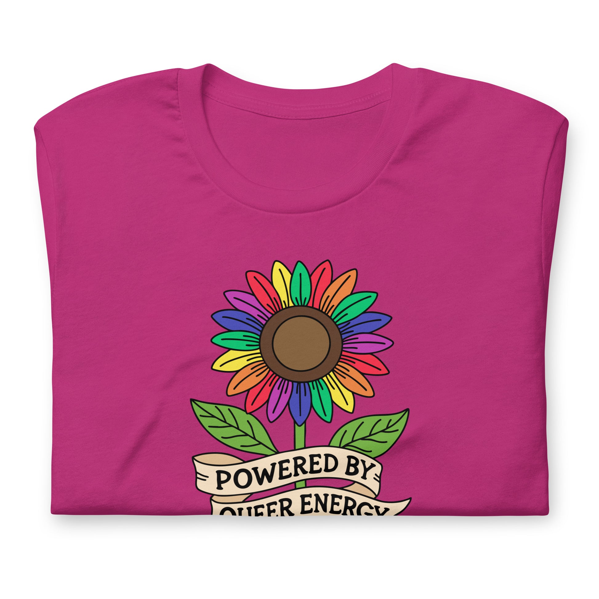 A folded magenta pink t-shirt featuring a colorful rainbow sunflower graphic with green leaves and a banner that reads 'POWERED BY QUEER ENERGY'.