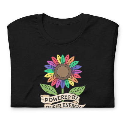 A black folded t-shirt featuring a colorful rainbow sunflower graphic with green leaves and a banner that reads 'POWERED BY QUEER ENERGY'.