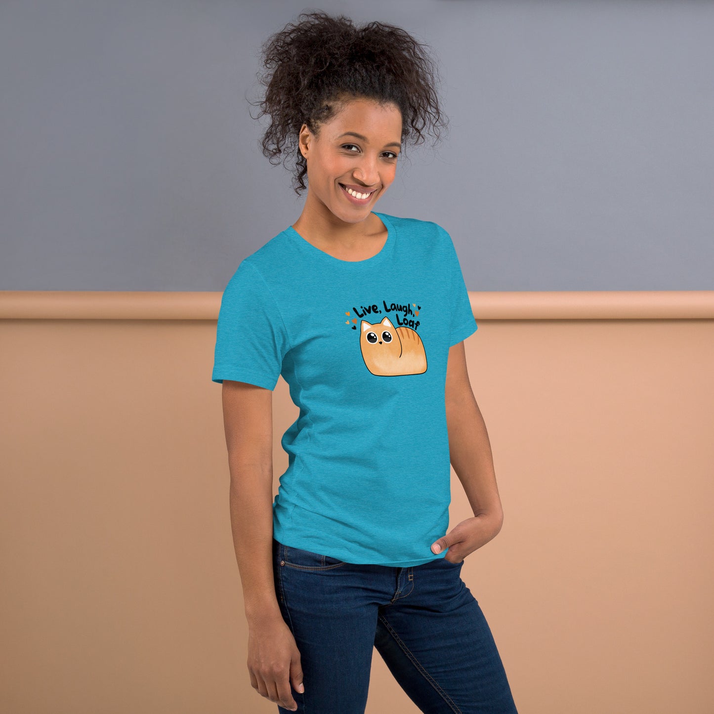 front right side profile of a woman wearing a heather aqua unisex t-shirt featuring the kawaii style cat and phrase Live Laugh Loaf