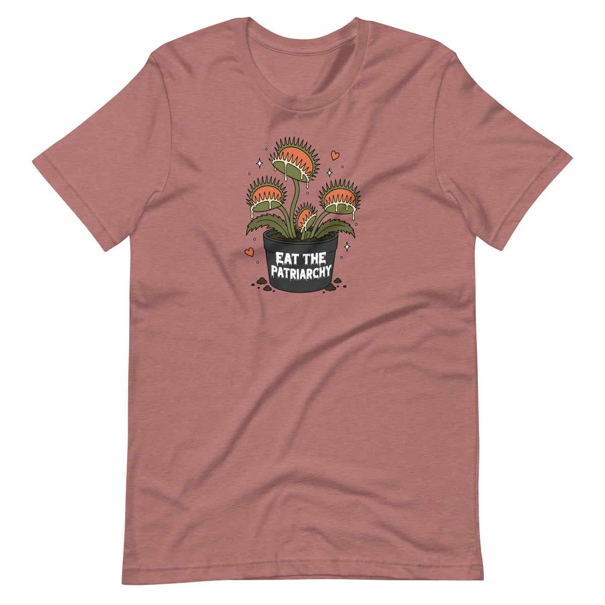 A dusty rose short-sleeve t-shirt with a graphic of three carnivorous Venus flytraps in a pot that reads 'EAT THE PATRIARCHY' in white text, shown on a plain white background.