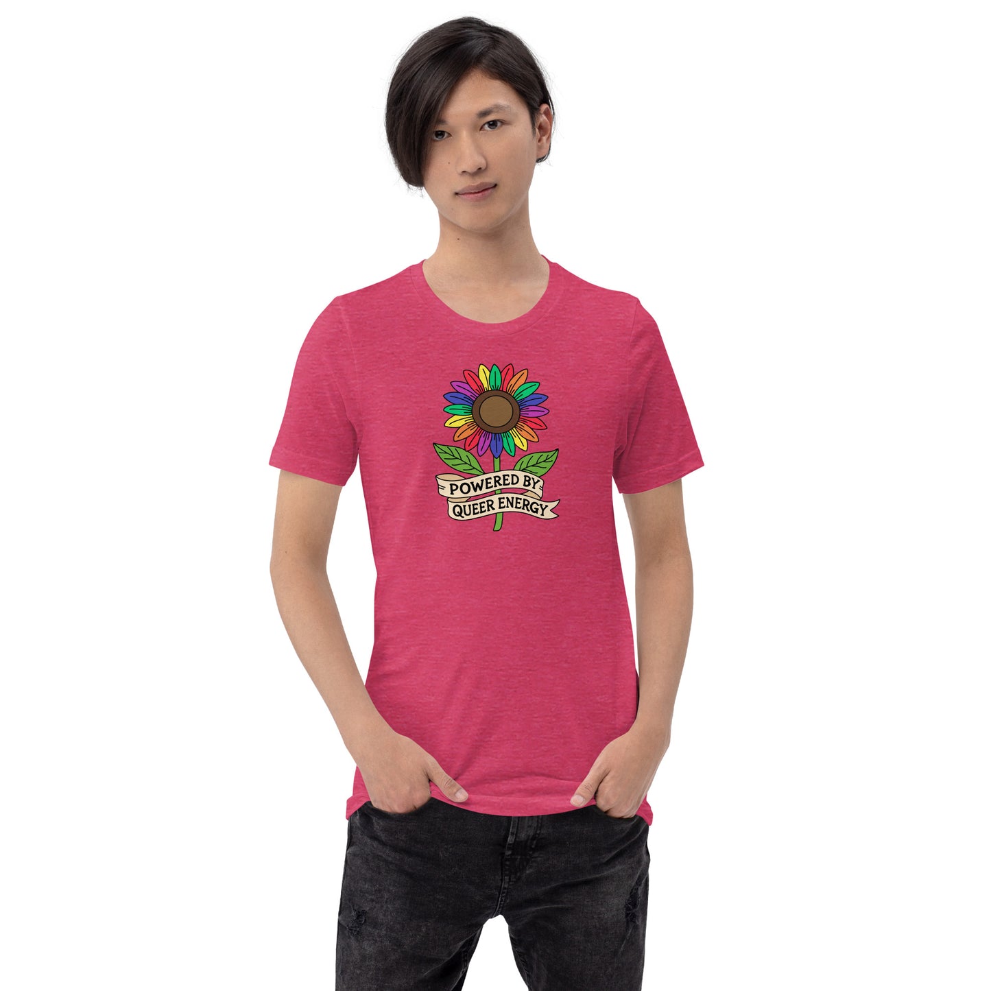 A model wearing a pink crewneck t-shirt with a colorful rainbow sunflower graphic and the text 'POWERED BY QUEER ENERGY' on the chest, paired with black jeans against a plain white background.