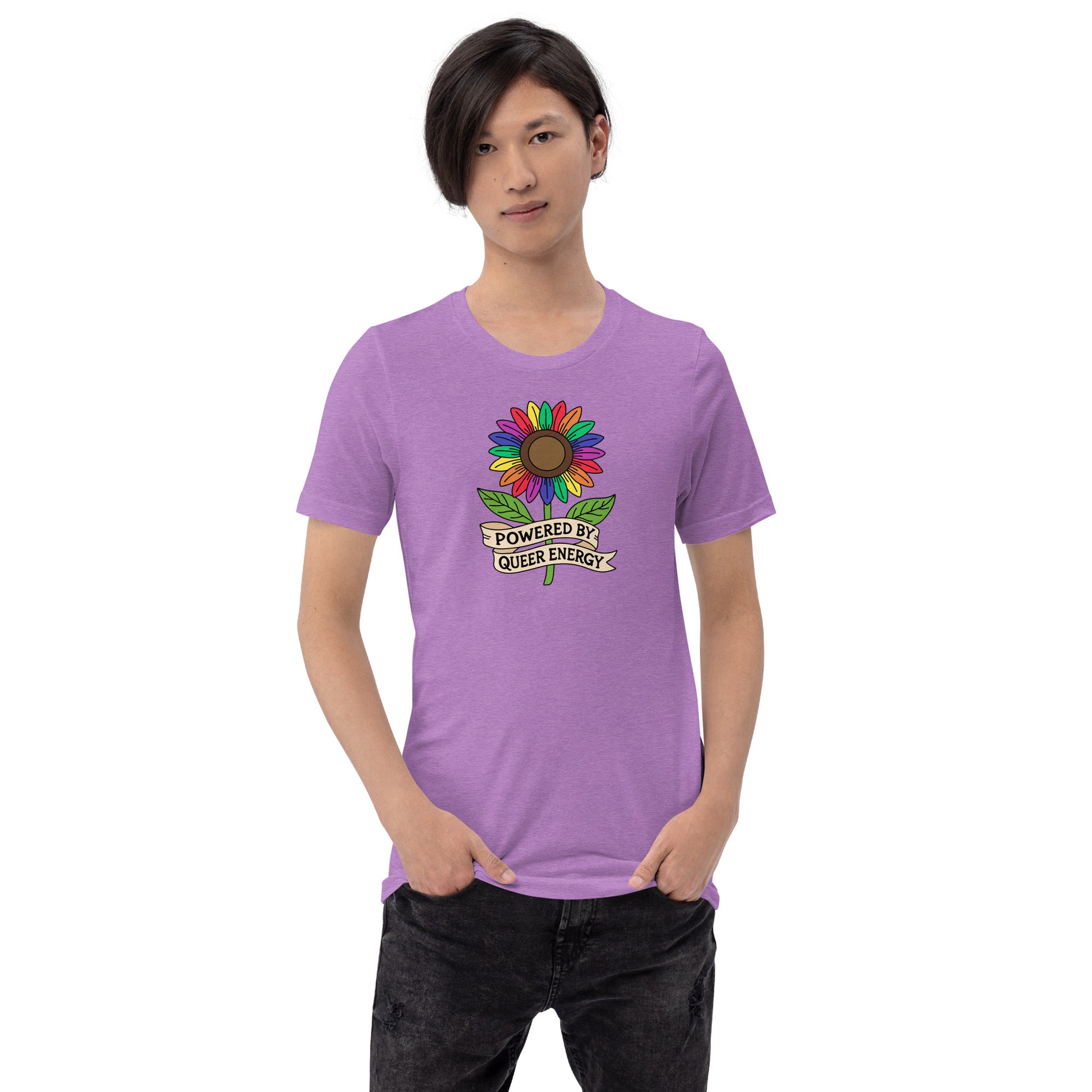 A model wearing a light purple short-sleeve t-shirt with a colorful rainbow sunflower graphic and the text 'POWERED BY QUEER ENERGY' on the chest, paired with black jeans against a plain white background.