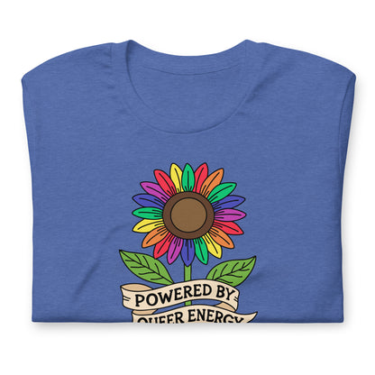 A folded heather blue t-shirt featuring a colorful rainbow sunflower graphic with green leaves and a cream banner that reads 'POWERED BY QUEER ENERGY'.