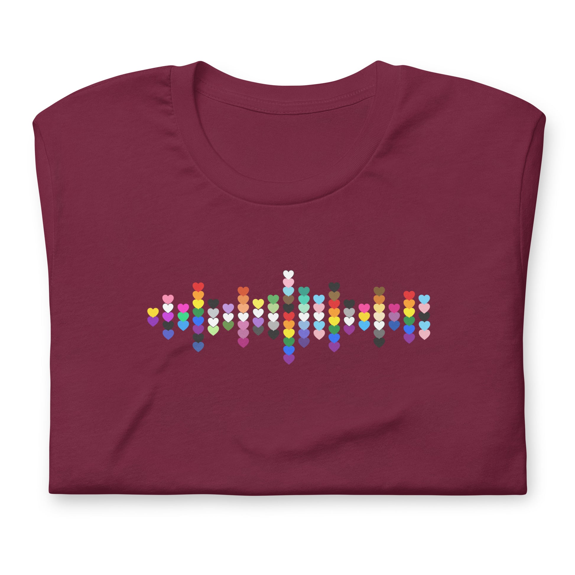A flat lay folded maroon t-shirt with a Pride Heart graphic design across the chest.