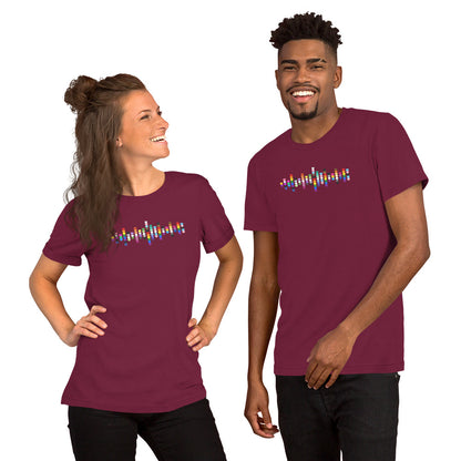 A smiling woman and man standing together, both wearing maroon t-shirts with a colorful Pride heart graphic on the chest.