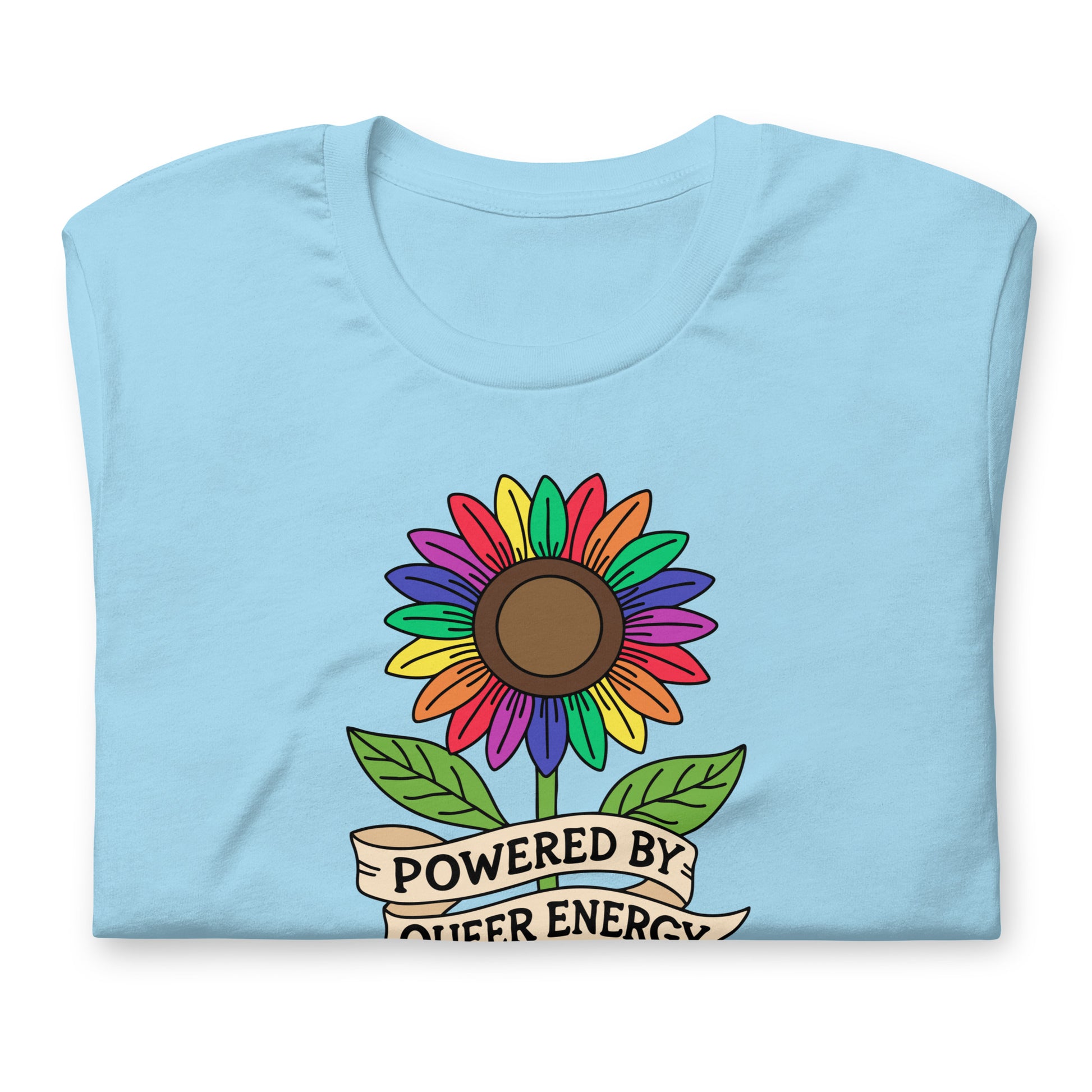 A light blue folded t-shirt featuring a colorful rainbow sunflower graphic with green leaves and a banner that reads 'POWERED BY QUEER ENERGY'.