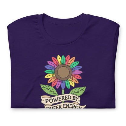 A folded dark purple t-shirt with a colorful rainbow sunflower graphic and a banner underneath that reads 'POWERED BY QUEER ENERGY'.