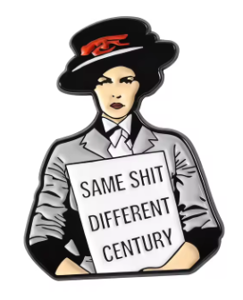 A die-cut enamel pin featuring a stylized illustration of a woman in a black hat with a red emblem, wearing a gray blazer and holding a sign that reads 'SAME SHIT DIFFERENT CENTURY' on a plain white background.
