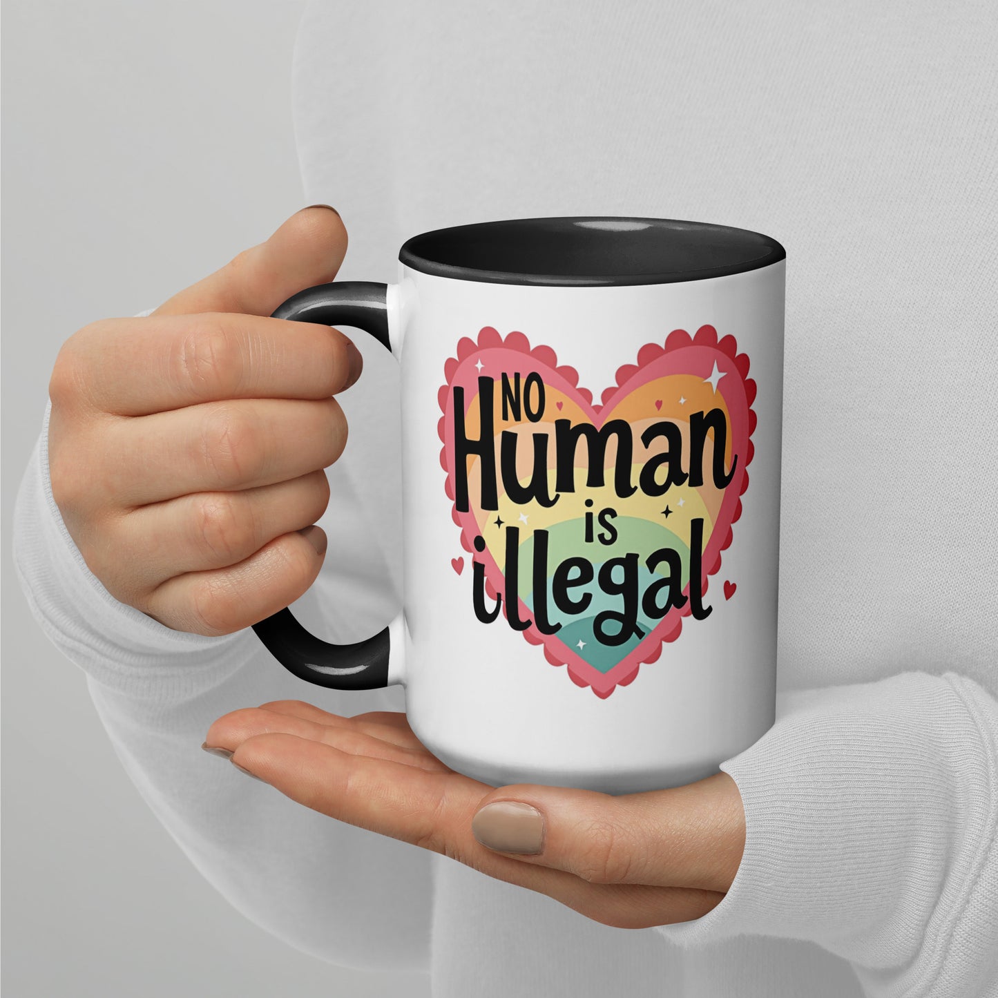 No Human is Illegal Rainbow Heart Accent Coffee Mug by Spinsterly Co, white ceramic with glossy finish