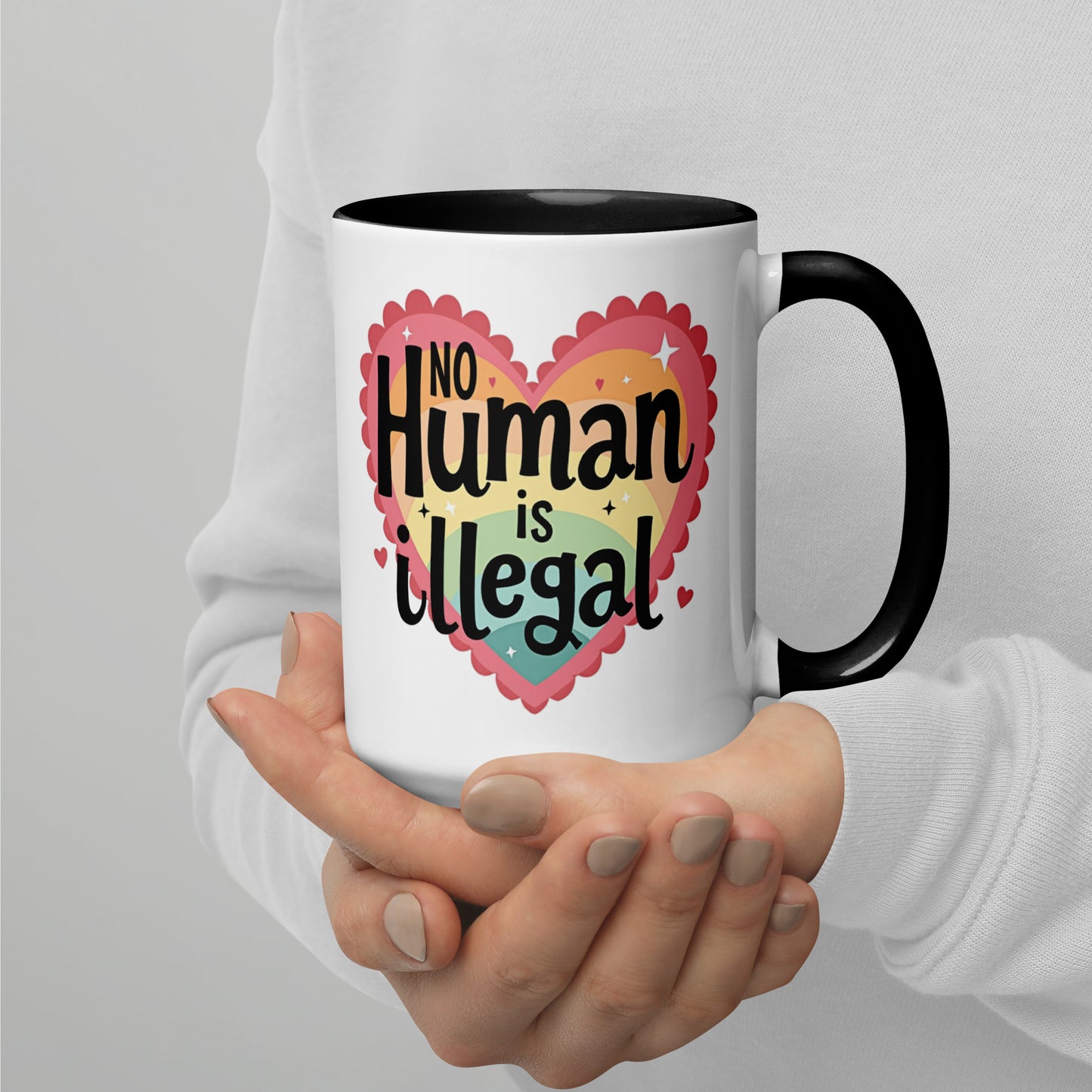 No Human is Illegal Rainbow Heart Accent Coffee Mug by Spinsterly Co, white ceramic with glossy rainbow heart