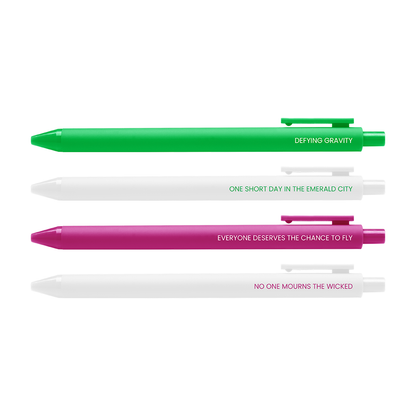 Three retractable pen-style markers are shown horizontally on a white background: a bright green pen reading 'DEFYING GRAVITY,' a white pen reading 'ONE SHORT DAY IN THE EMERALD CITY,' and a magenta pink pen reading 'EVERYONE DESERVES THE CHANCE TO FLY' and 'NO ONE MOURNS THE WICKED.'.