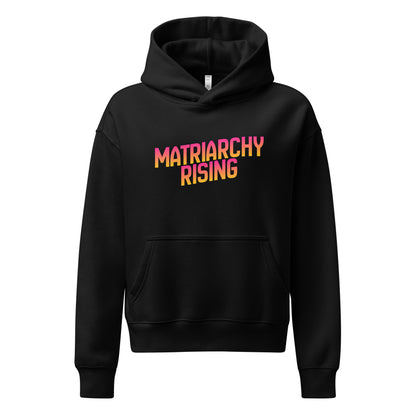 Black Matriarchy Rising hoodie with bold sunrise-gradient lettering across the chest.