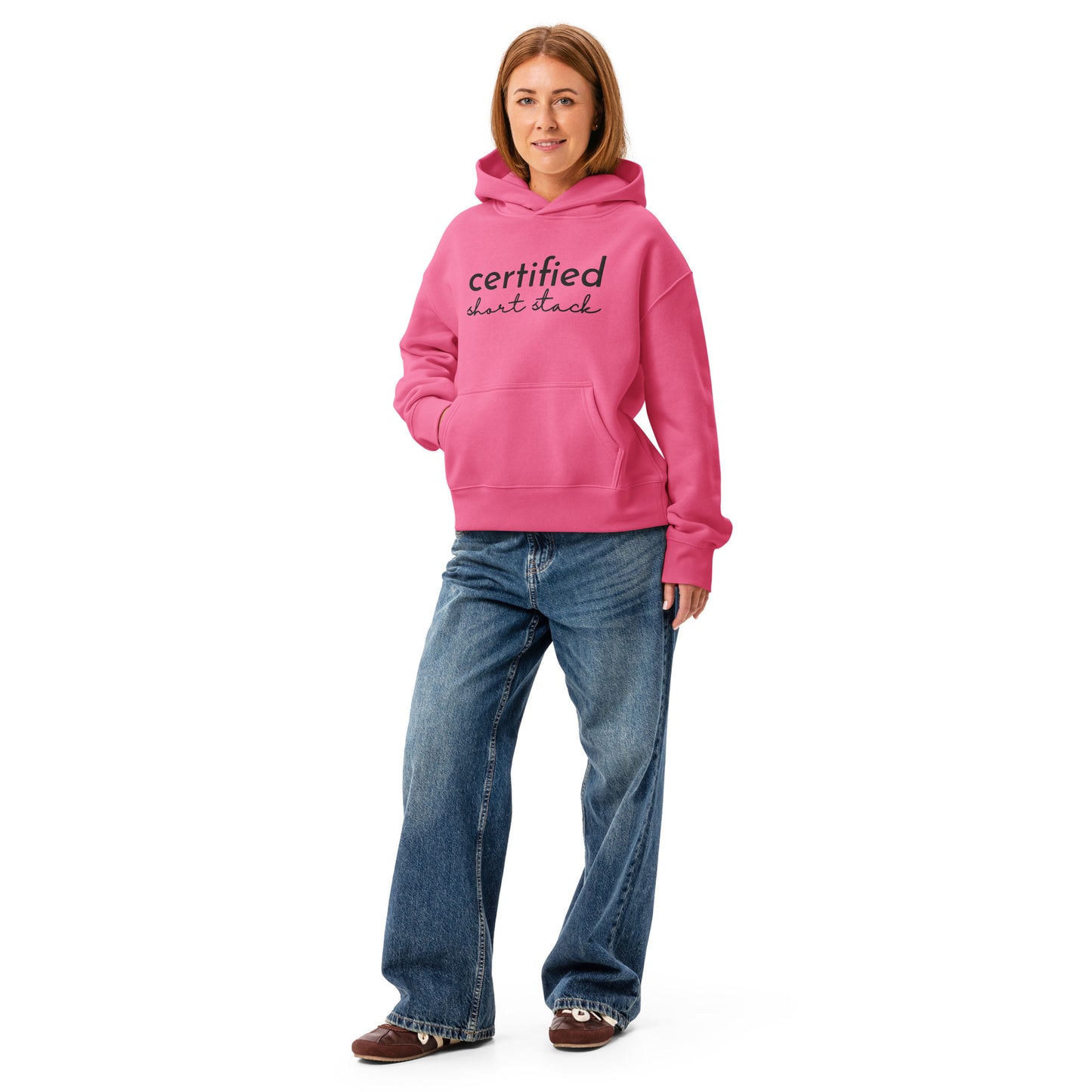 Person wearing a pink hoodie with a cat graphic and blue jeans on a white background