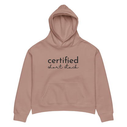 A dusty rose pink cropped hoodie with 'certified short stack' printed in black across the chest, displayed on a clean white background.