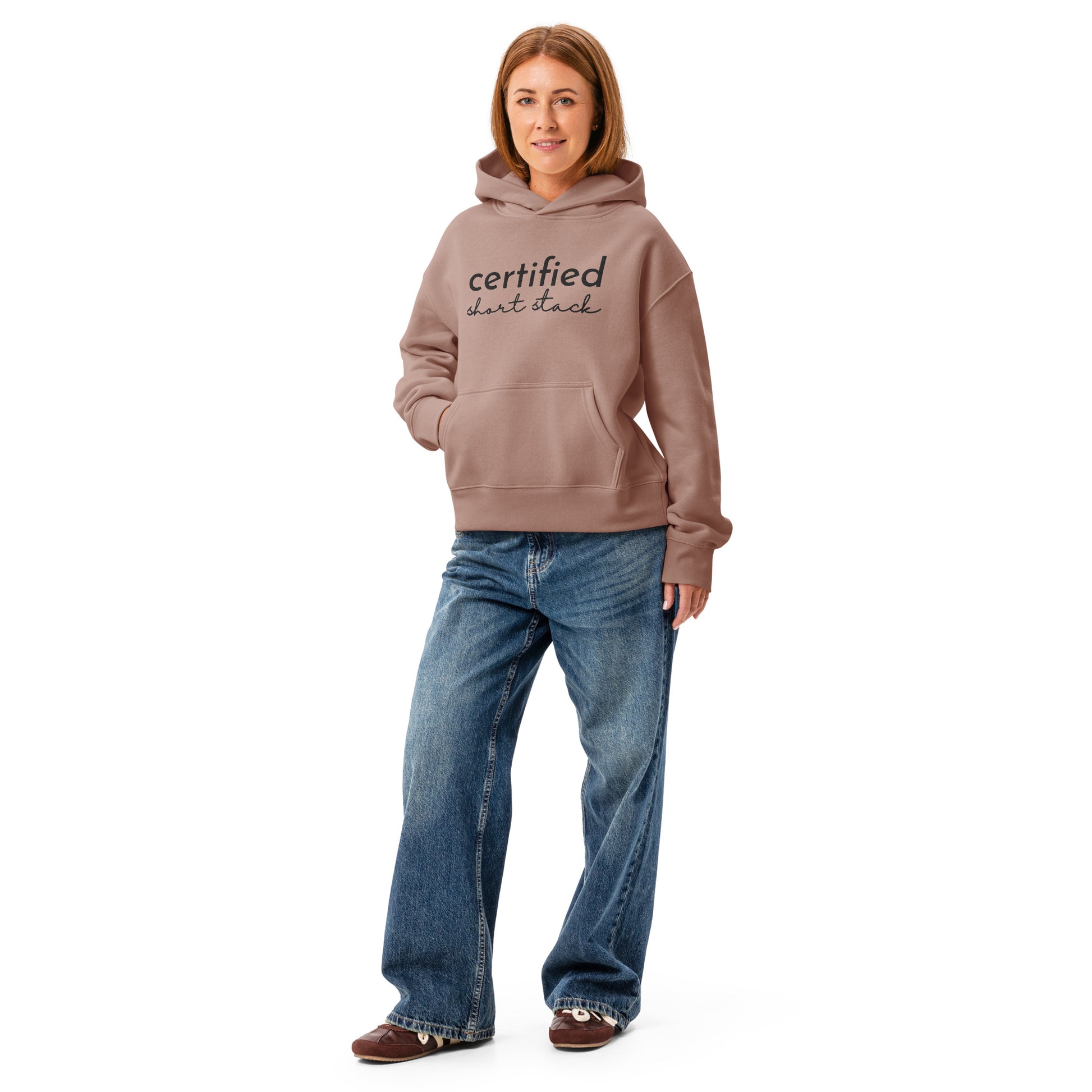 Person wearing a hoodie with text and blue jeans on a white background