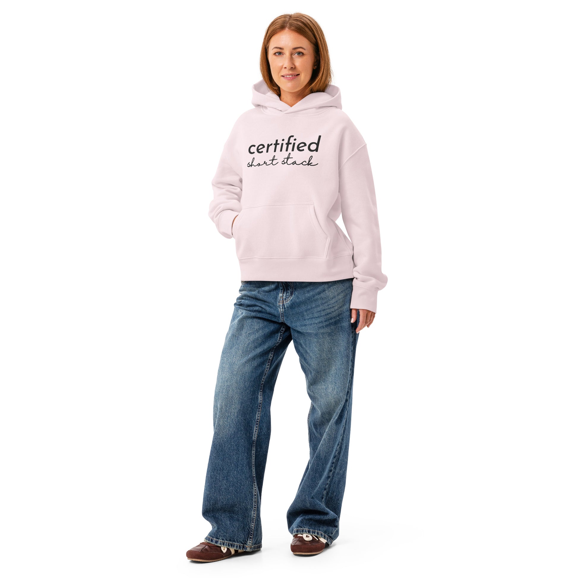 Person wearing a light pink hoodie and blue jeans on a white background